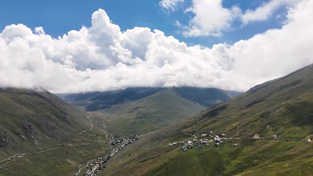 Aerial video of the breathtaking Kackar Mountains in Rize, Turkiye, with clouds gently caressing the peaks on a sunny day