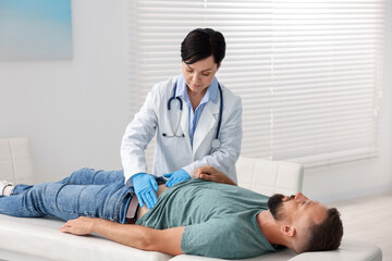 Fototapeta premium Gastroenterologist examining patient with stomach pain in clinic