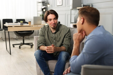 Fototapeta premium Colleagues having conversation during break in armchairs at office