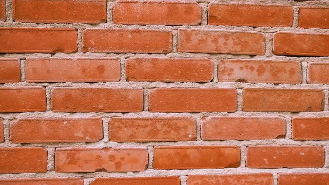 Close up of a brick wall with orange bricks and gray mortar in full frame