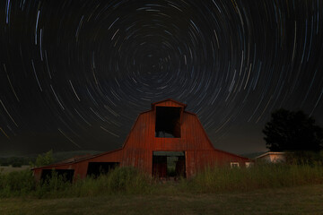 Old Red Barn at night with star trails of Polaris the North Star