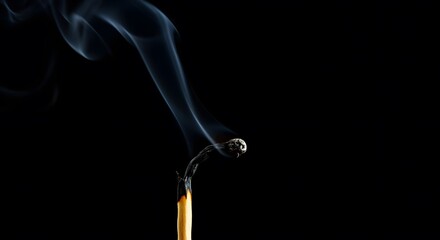 Close-up of Burning Matchstick with Smoke Rising on Black Background