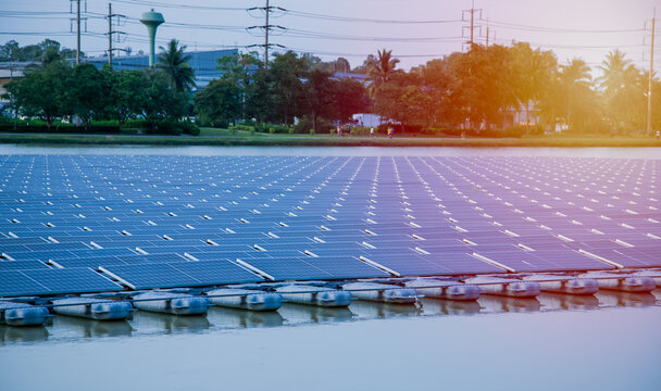 Solar farm panels in aerial view, rows array of polycrystalline silicon solar cells or photovoltaics in solar power plant floating on the water in lake, Alternative renewable energy.