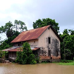 Fototapeta premium Old weathered house by a river