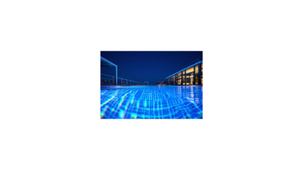 Illuminated infinity pool at night with glowing blue water reflecting the modern architecture of a luxury hotel resort.