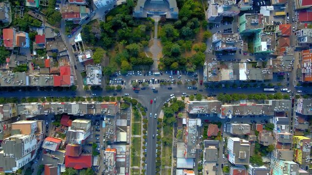 Flat aerial view of a T-junction in Durr&euml;s, Albania, showing intersecting roads, surrounding houses, and urban layout under a sunny sky.