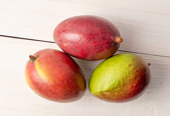 Sweet juicy mangoes on a wooden table, top view, macro.	