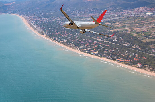Airplane flying over beach of Gava - Barcelona, Spain