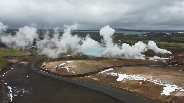 Spectacular aerial drone footage soaring above the geothermal area near Lake M&yacute;vatn, North Iceland. Captures powerful steam vents (fumaroles) hissing and swirling over colorful, mineral-rich earth.