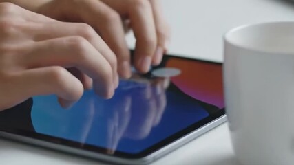 Hands actively typing on a tablet with a coffee mug nearby, capturing a moment of modern productivity and digital engagement in a bright, clean workspace. - indoors cafe scene - Powered by Adobe
