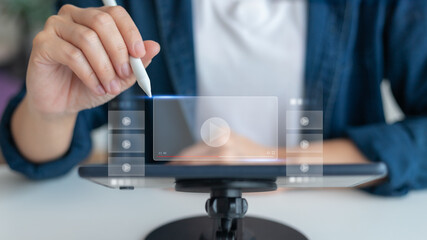 Close-up of a hand using a stylus with an online video streaming interface on a tablet, symbolizing digital media, content creation, and e-learning.