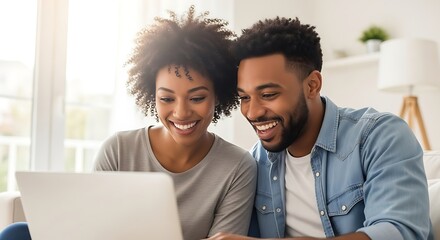 A happy African American couple smiles brightly, engaged with a laptop at home. Perfect for themes of shared digital experiences, online learning, or remote work.