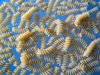 Fusilli pasta pattern on blue background