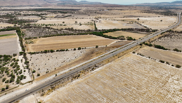 Vista a&eacute;rea de carretera en zona agr&iacute;cola semi&aacute;rida
Paisaje rural con parcelas y camino principal