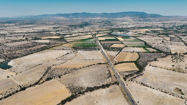 Vista a&eacute;rea de carretera en zona agr&iacute;cola semi&aacute;rida
Paisaje rural con parcelas y camino principal