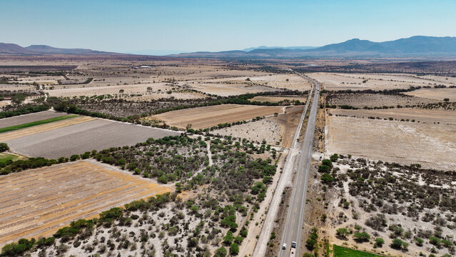 Vista a&eacute;rea de carretera en zona agr&iacute;cola semi&aacute;rida
Paisaje rural con parcelas y camino principal
