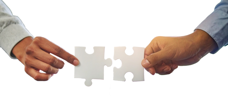 Two professional hand connecting two puzzle pieces on a desk