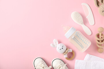 Bottle with milk and baby accessories on light pink background, flat lay. Space for text