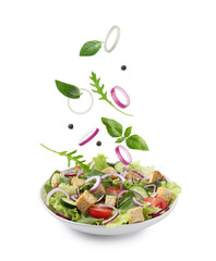 Croutons and other ingredients falling into bowl of salad against white background