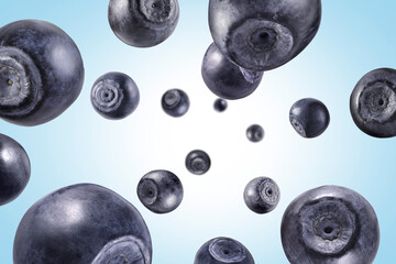 Fresh ripe blueberries swirling in air against pale blue background