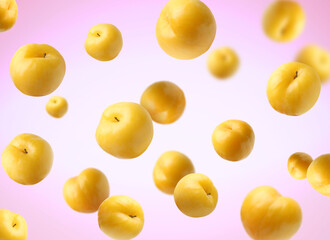 Fresh ripe cherry plums falling on color gradient background