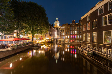Amsterdam by night in the Netherlands, with canals, lights, reflections int the water
