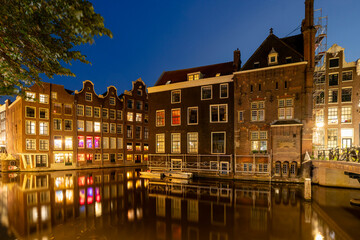 Obraz premium Amsterdam by night in the Netherlands, with canals, lights, reflections int the water