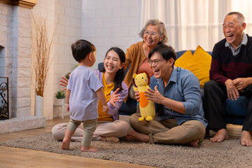 A happy ASEAN family living together as a big family is together in the living room at home, and behind is a sofa.