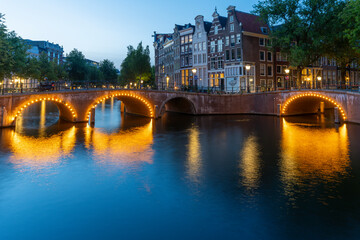 Naklejka premium Amsterdam by night in the Netherlands, with canals, lights, reflections int the water
