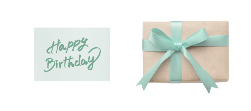 Overhead view of a green ribbon gift box and a happy birthday card with green handwritten lettering