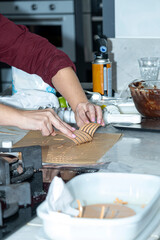 Chef using plastic to finish a caramel chocolate decoration.