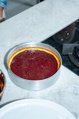 Cheesecake with red fruit topping on a marble countertop_vertical.