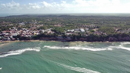 Aerial view of Pipa Beach (Praia de Pipa) in Rio Grande do Norte, Brazil. This scenic landscape shows the tropical town on the cliffs, the Atlantic Ocean, and the lush surrounding nature.