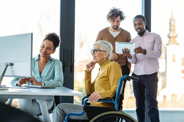 The image includes a person using a wheelchair, depicting inclusivity and teamwork in modern office
