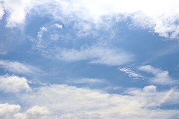 Obraz premium Bright blue sky with soft, fluffy white clouds drifting peacefully, creating a serene and refreshing view of nature’s beauty. Suitable for nature and simple background.