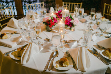 Elegant dining setup with floral centerpiece and candles at a special event in a luxurious venue during the evening