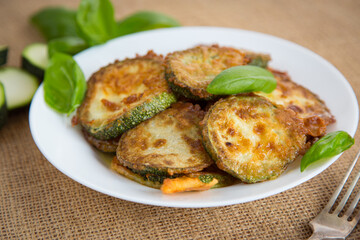 Golden zucchini slices in a crispy homemade breading on a rustic table