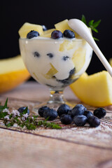 Summer vitamin cream yogurt with melon blueberries on a wooden