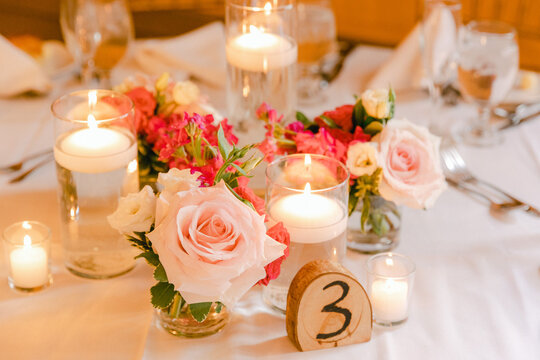 Beautiful table centerpiece with roses, candles, and elegant decor for a special event in soft lighting