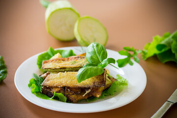 Golden fried zucchini on a brown background