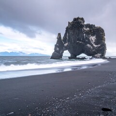 Dramatic black sand beach with arching rock