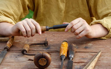 Man is sitting at a table with a variety of tools, including a pair of pliers