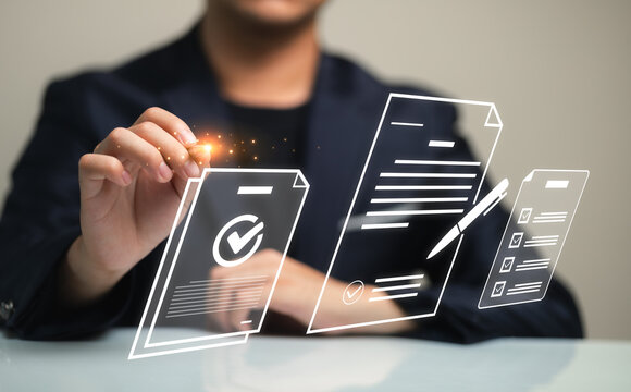 A professional office scene featuring a hand holding a pen above digital documents and a checklist, symbolizing efficiency and successful planning in business.