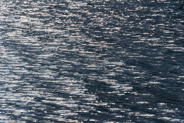 The texture of the lake's water surface, with small ripples, small waves and reflections on an overcast day.