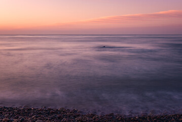 Solitude at Sunrise: Tranquil Beach with Smooth Water Effect
