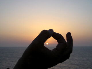 Capturing the Sun with Framed Fingers at Sunrise or Sunset