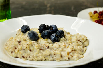 A bowl of oatmeal topped with fresh blueberries. 