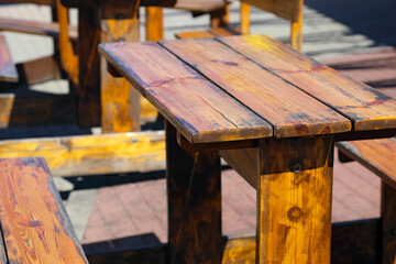 The outdoor restaurant has wooden tables and benches for guests