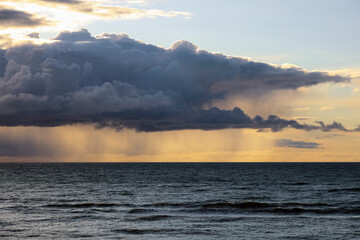 The unique landscape is the result of rain clouds and a sunset over the Baltic Sea in Mielno, Poland