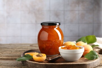 Tasty apricot jam and fresh fruits on wooden table, closeup. Space for text